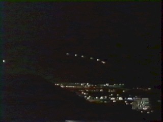 Phoenix Lights photo - geometrical formation of 6 objects to right with 1 brighter object to left, above city lights